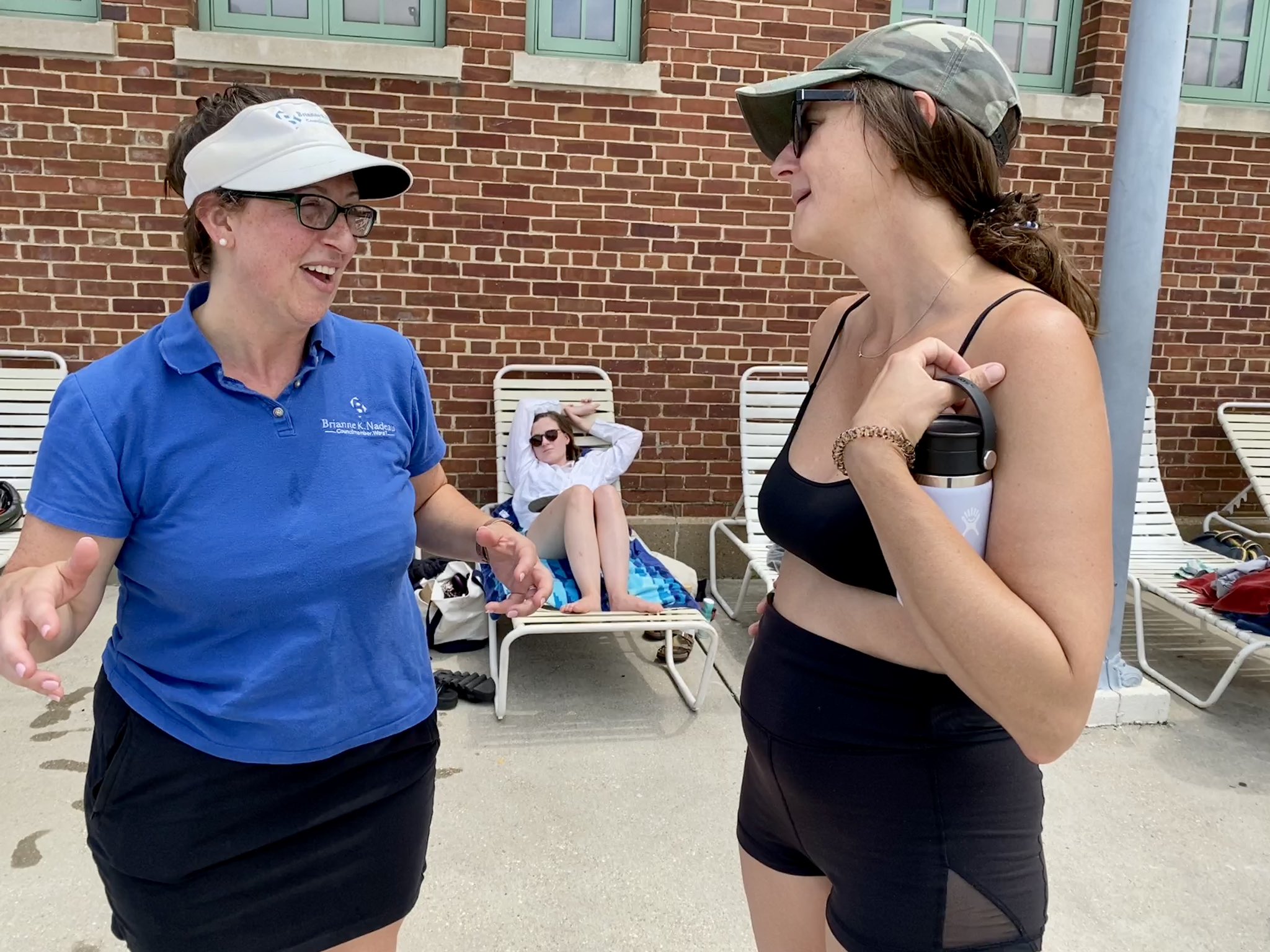 Councilmember Nadeau speaks with a resident next to a pool