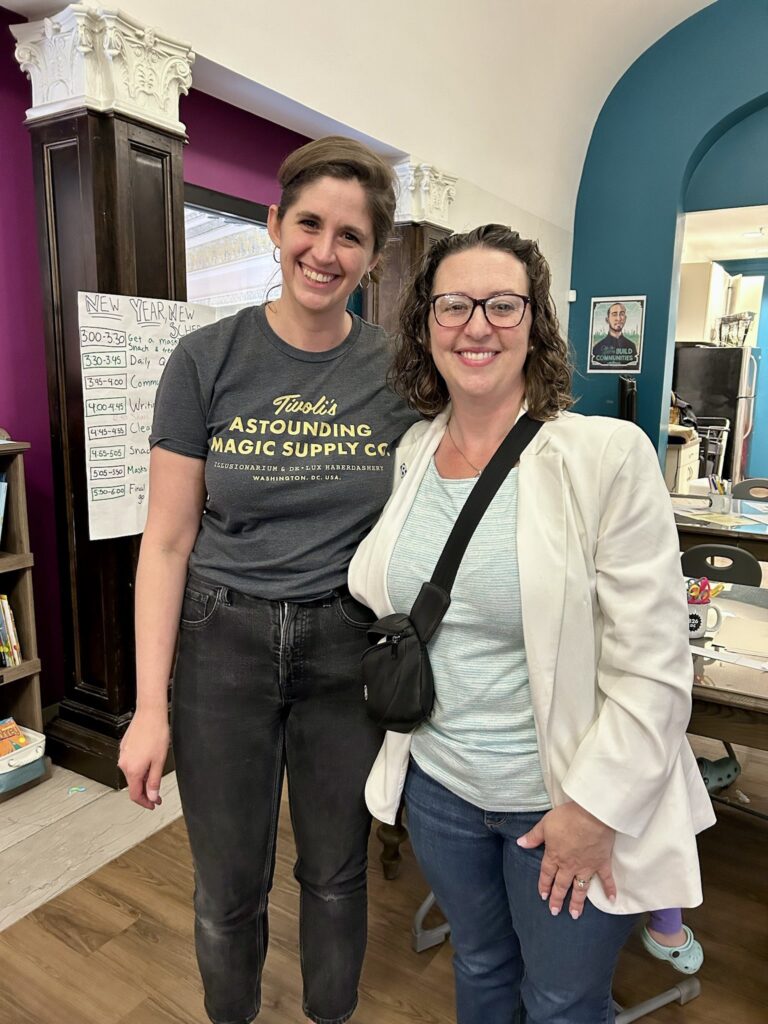 Councilmember Brianne Nadeau poses with woman at 826DC; young girl draws with markers at craft table