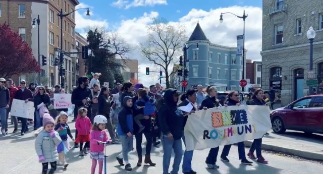 Photo of rally to save Rosemount, people marching and carrying banner that says Save Rosemount