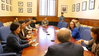 Councilmembers Nadeau and Frumin sit across a conference table from  members of the delegation from Incheon, South Korea. Chairman Mendelson is seated at one end of the table, his back to the camera, while a member of the South Korean team sits across from him.