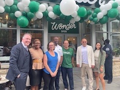 Councilmember Nadeau and others pose on front of a storefront with a sign reading “Wonder” about be the door.