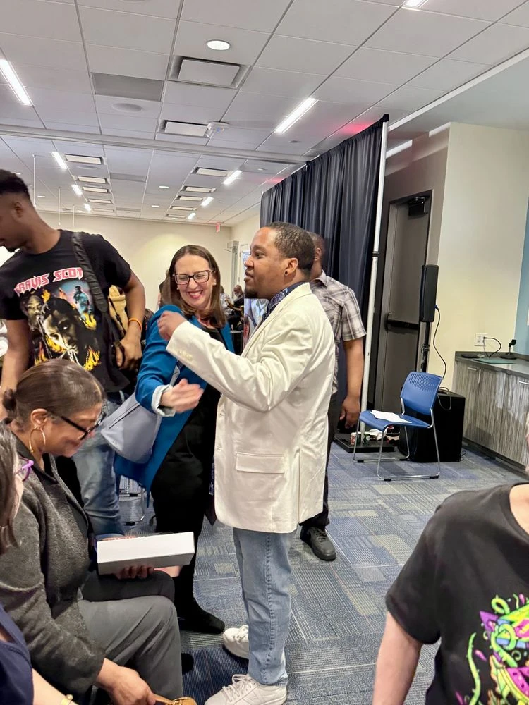 Councilmember Nadeau gives a hug to a guest.