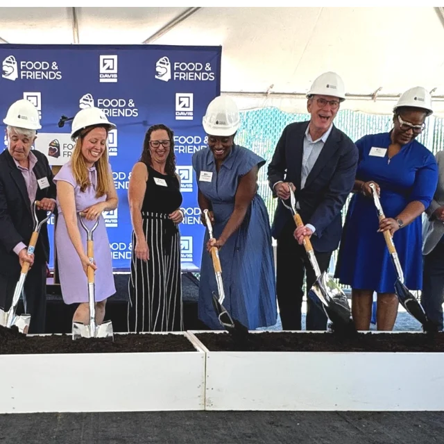 Group of people with hardhats and shovels for a ceremonial groundbreaking