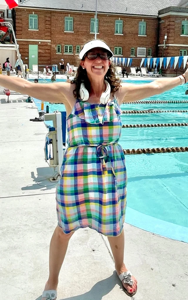 Councilmember Nadeau smiling, outstretched arms poolside