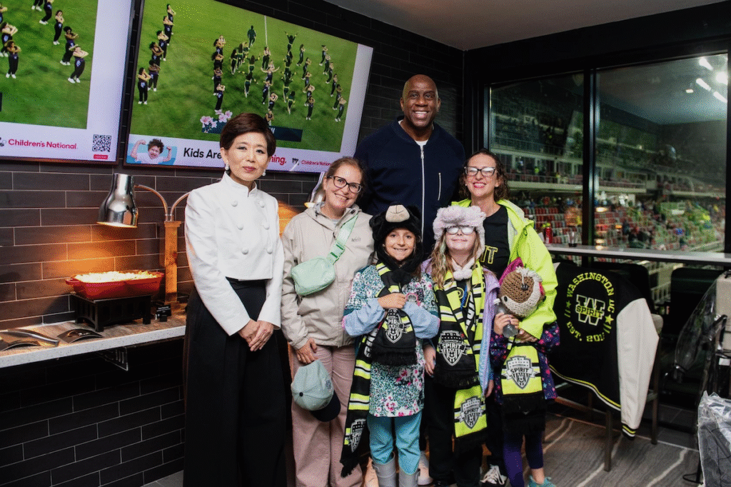 Posed photo with Michele Kang, Magic Johnson, Brianne Nadeau, and guests at a Washington Spirit match