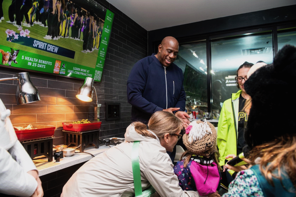 Magic Johnson greets Councilmember Nadeau's daughter at a Washington Spirit match at Audi Field